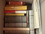 une boîte remplie de livres posés sur le sol