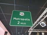 a green street sign hanging from the ceiling of a building