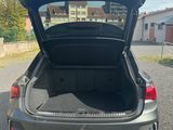 l'arrière d'une voiture dont le coffre est ouvert, sur un parking