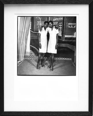 black and white photograph of two women in white dresses standing next to each other