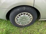 une voiture garée dans l'herbe, avec une roue dessus