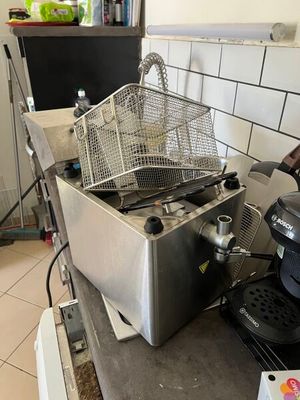 une photo d'une cuisine professionnelle équipée d'une friteuse et d'une cafetière