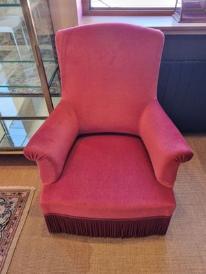 pink chair with pleated seat and foot rest in front of a window