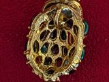 a gold brooch on a red cloth