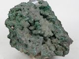 a close up of a piece of green mineral on a white surface