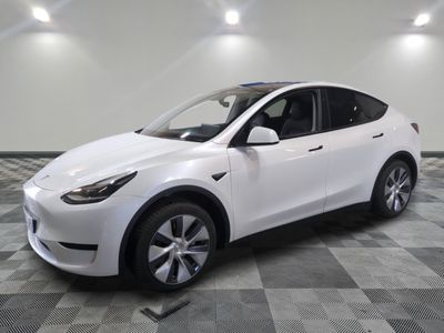 un SUV Tesla blanc garé dans un garage dont le sol est en damier
