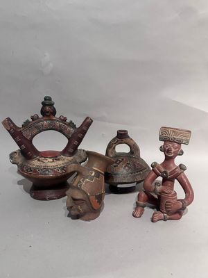 trois figurines assises l'une à côté de l'autre