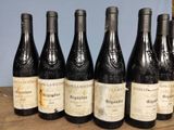 six bottles of wine are lined up in a row on a table