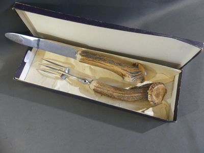 a box with a knife, fork, and antelope in it