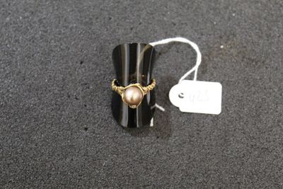a ring with a pearl on it sitting on a table