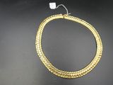 gros plan d'un collier en or sur une surface noire