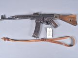 an ak - 47 machine gun with a leather sling on a white surface