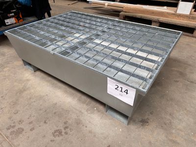une photo d'une table basse en acier et en verre dans un entrepôt