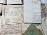 a pile of old papers on a table next to a book