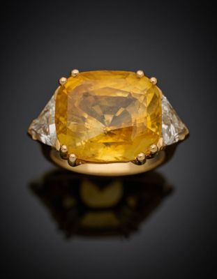 un gros plan sur une bague sertie d'un saphir jaune et de diamants