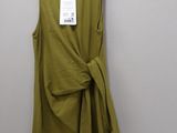 a green dress hanging on a hanger on a wall