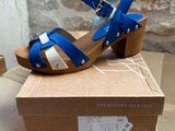 a close up of a pair of blue and white sandals on a cardboard box