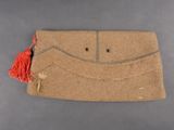 an old purse with a red tassel hanging from it ' s side