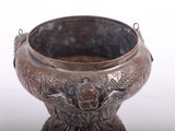 a metal bowl with a handle on a white surface