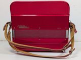 a red accordion sitting on top of a white table