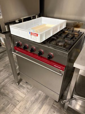 une cuisinière avec une casserole posée dessus, dans une cuisine