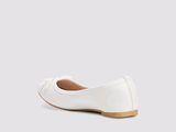 La femme porte des chaussures blanches ornées d'un nœud sur le côté.