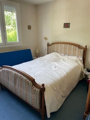 un lit qui se trouve dans une pièce où il y a un canapé bleu