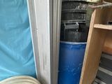 a blue trash can sitting next to a stack of trash cans