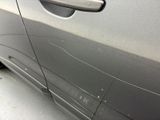 the door handle of a silver car with scratches on it