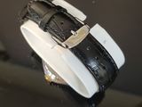 a black and white watch on display on a black table