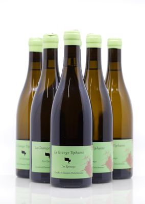 quatre bouteilles de vin sont alignées sur une surface blanche