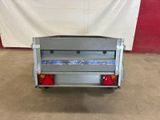 the back end of a silver truck with a red light on it