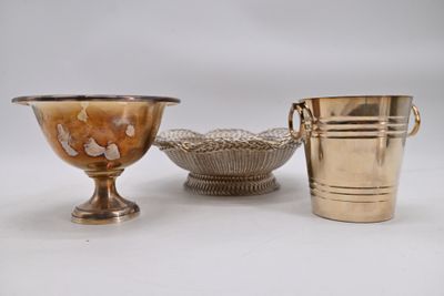 deux vases en argent et un bol en argent posés sur une surface blanche