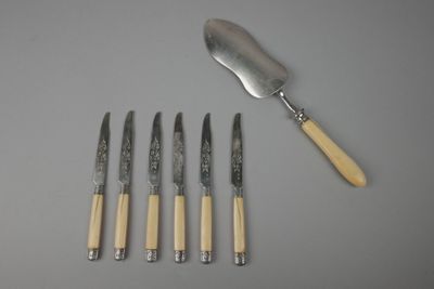 trois couteaux et une fourchette sont posés les uns à côté des autres sur une table