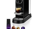 une machine à café noir avec une tasse de café à côté