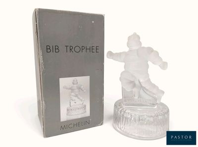 une figurine en verre représentant un homme sur un snowboard devant une boîte