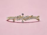 un gros plan d'une bague en or sertie de diamants sur fond rose