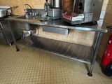 une cuisine avec une table en inox et un extincteur rouge à côté