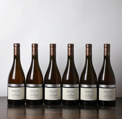 six bouteilles de vin sont alignées sur une table en bois
