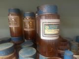 many jars of honey sitting on a shelf next to each other
