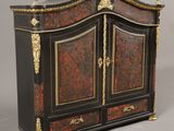 une armoire peinte en noir et or, à deux portes