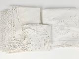 three pieces of white lace on a white table cloth