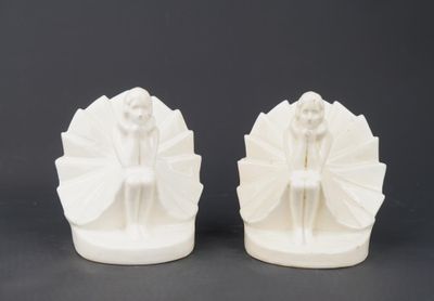 two white ceramic figurines of a woman and a man
