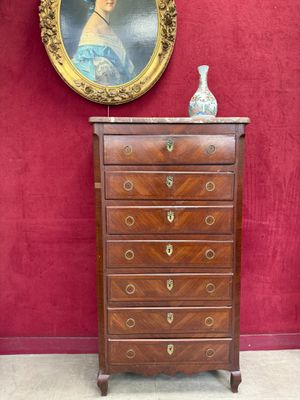 a small chest of drawers with a painting on the wall behind it