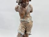 statue of a boy on a rock with a bird in his hand