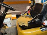 a yellow forklift with a black seat in a warehouse