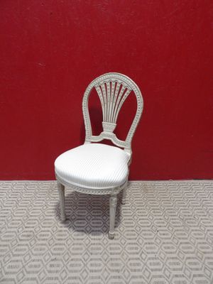 chaise en osier blanc devant un mur rouge