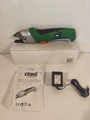 a green and black electric tool sitting on top of a white box