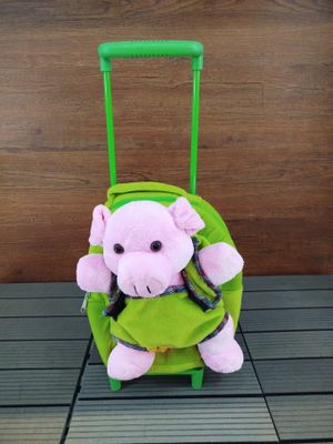 une peluche assise sur une valise verte