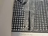 an open book with a black and white drawing of a man standing in front of a tall building
